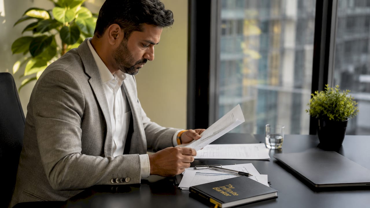 Hands using calculator with financial documents on table