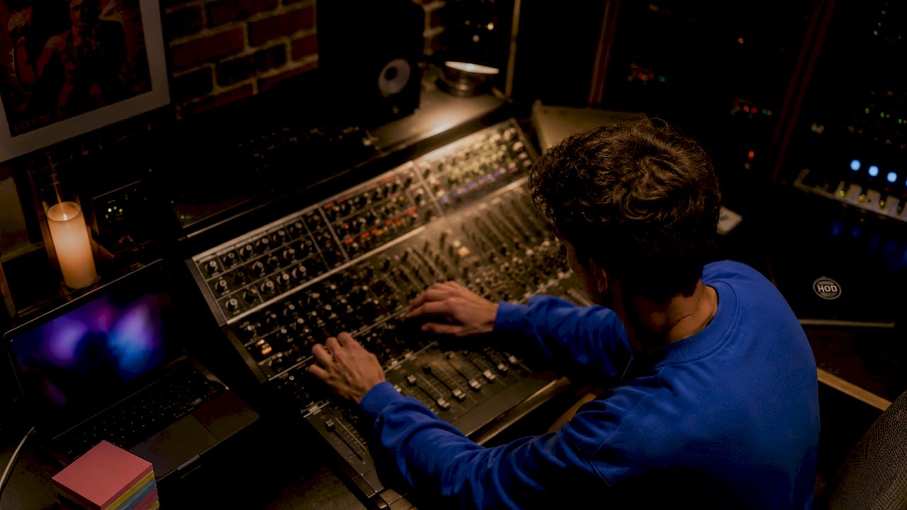 Hands adjusting video editing controls in creative suite