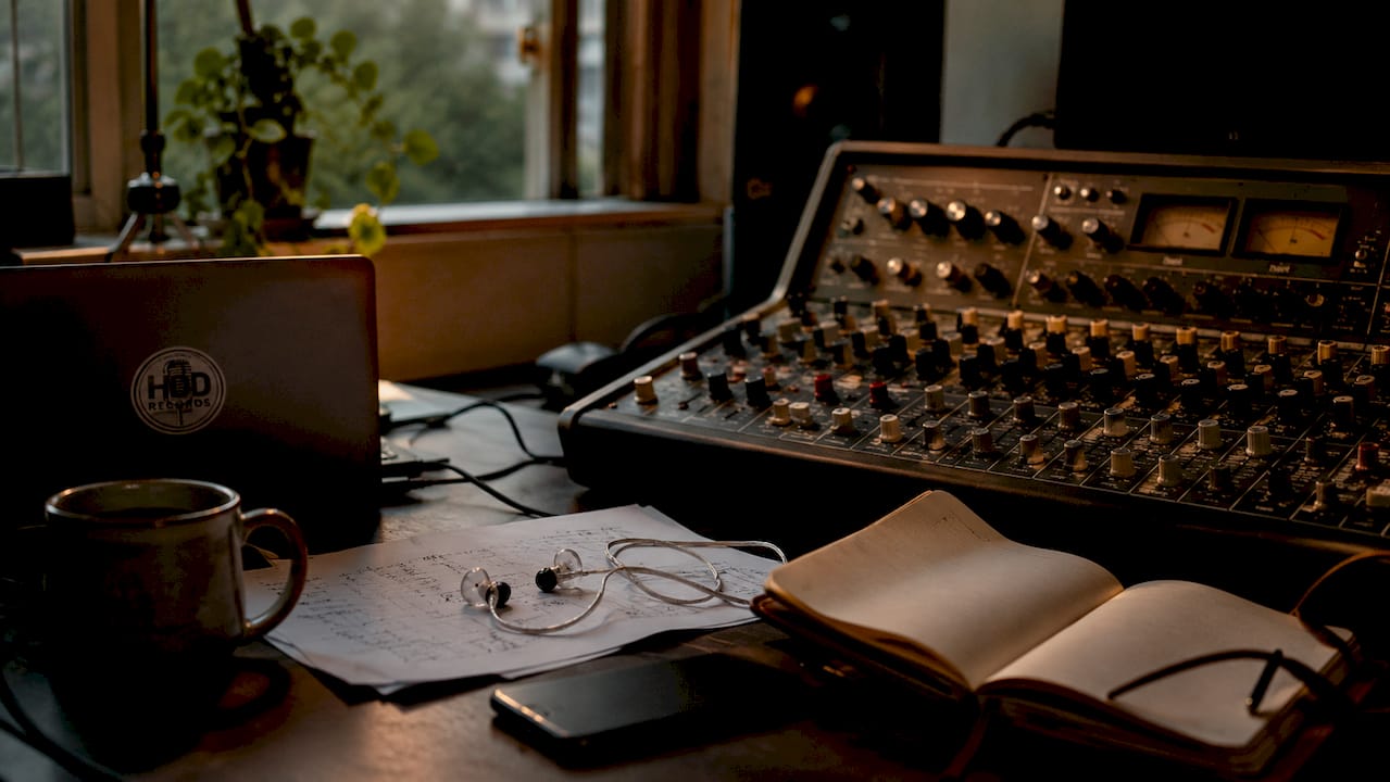 Music producer's home studio with mixing console and lyric sheets