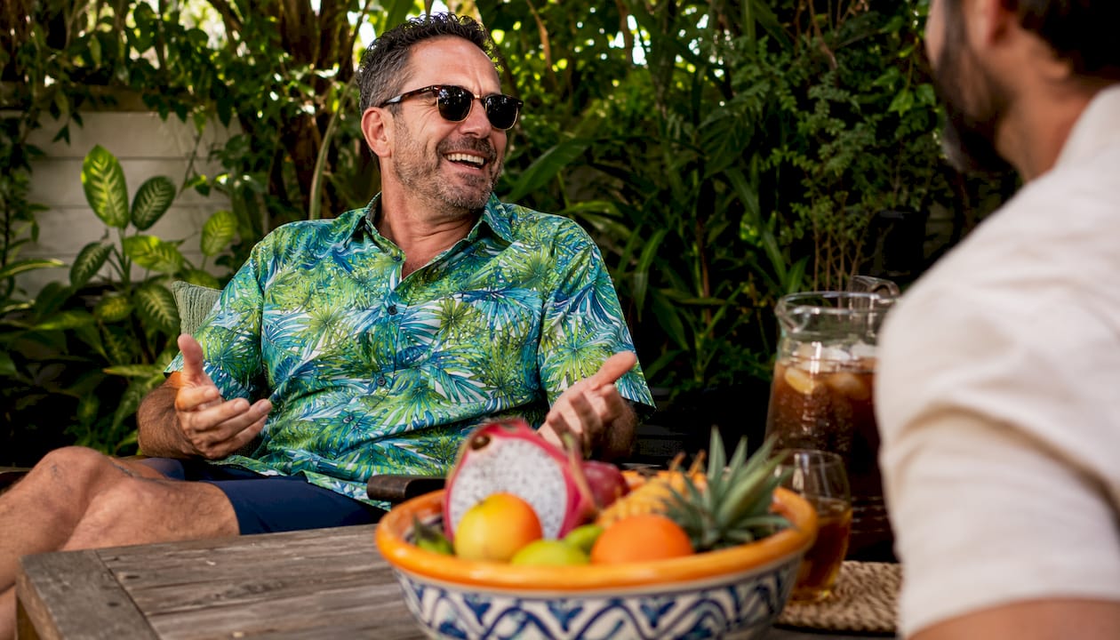 Man wearing Dan Flashes tropical shirt at backyard patio BBQ