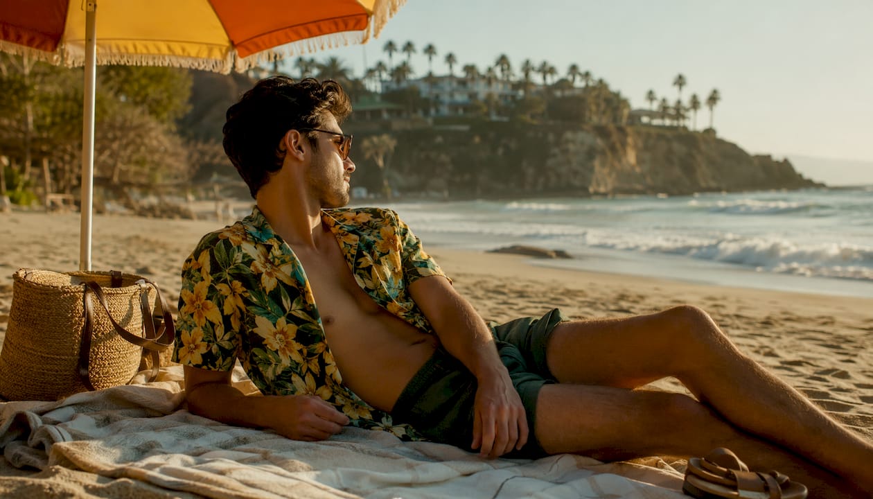 Man wearing open Dan Flashes shirt over swimwear at beach patio
