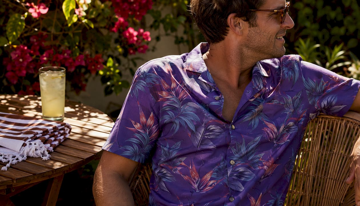 Man sitting poolside in Dan Flashes purple tropical shirt