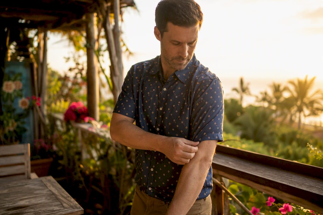 Man smoothing polyester Dan Flashes shirt sleeve