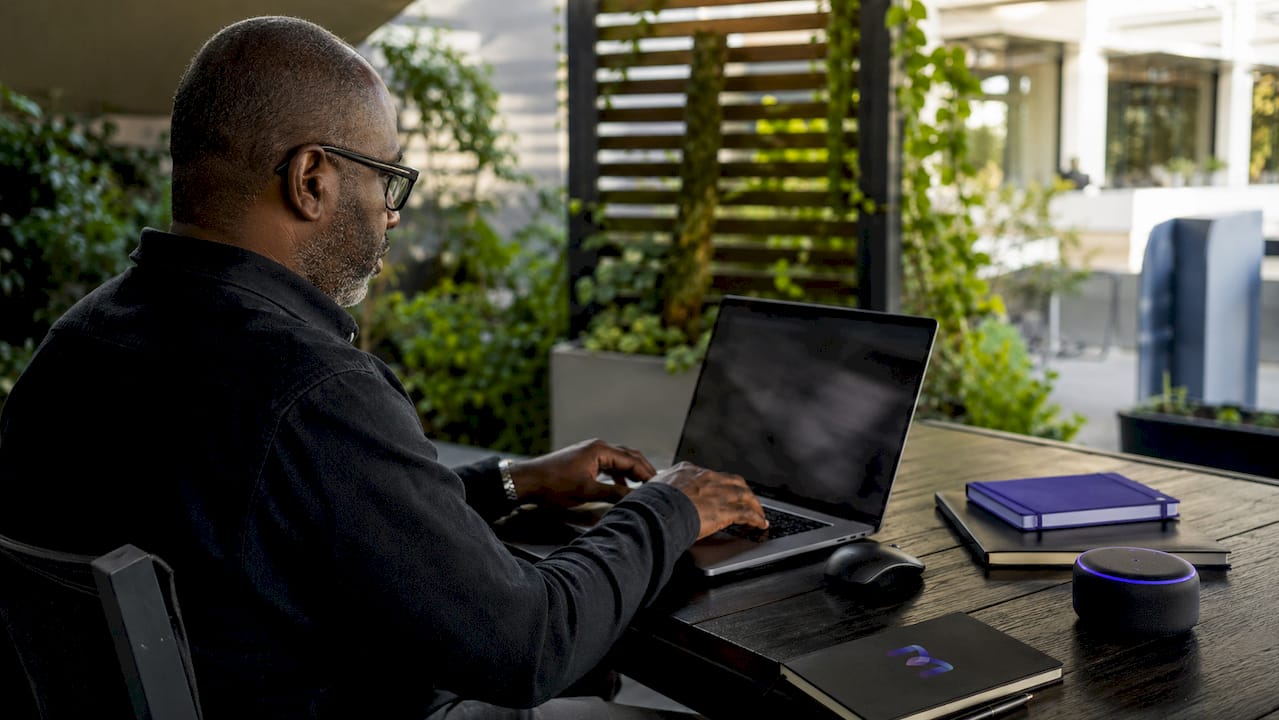 Hands typing on desk with smartphone and notes