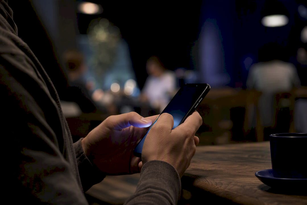 Hand holding smartphone ready to type chatbot message