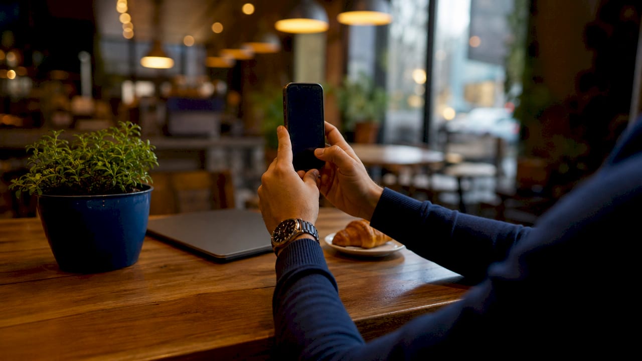 Hands taking screenshot of infringing webpage on smartphone