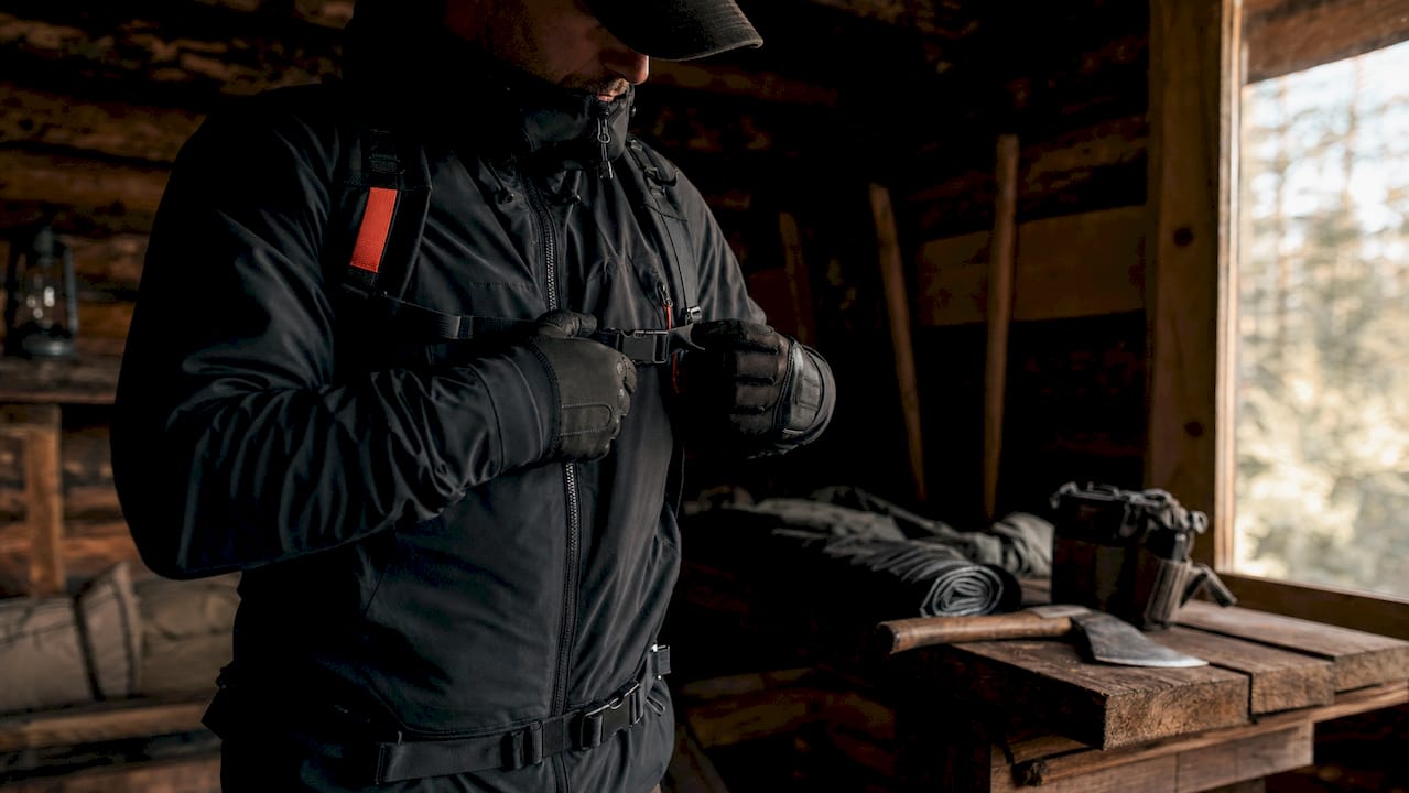Gloved hands testing hunting jacket zipper and buckle