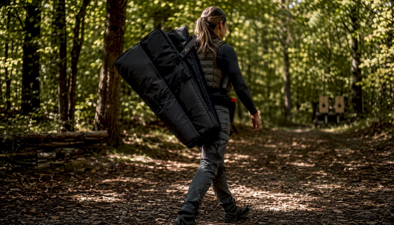 Woman carrying double soft rifle bag outdoors