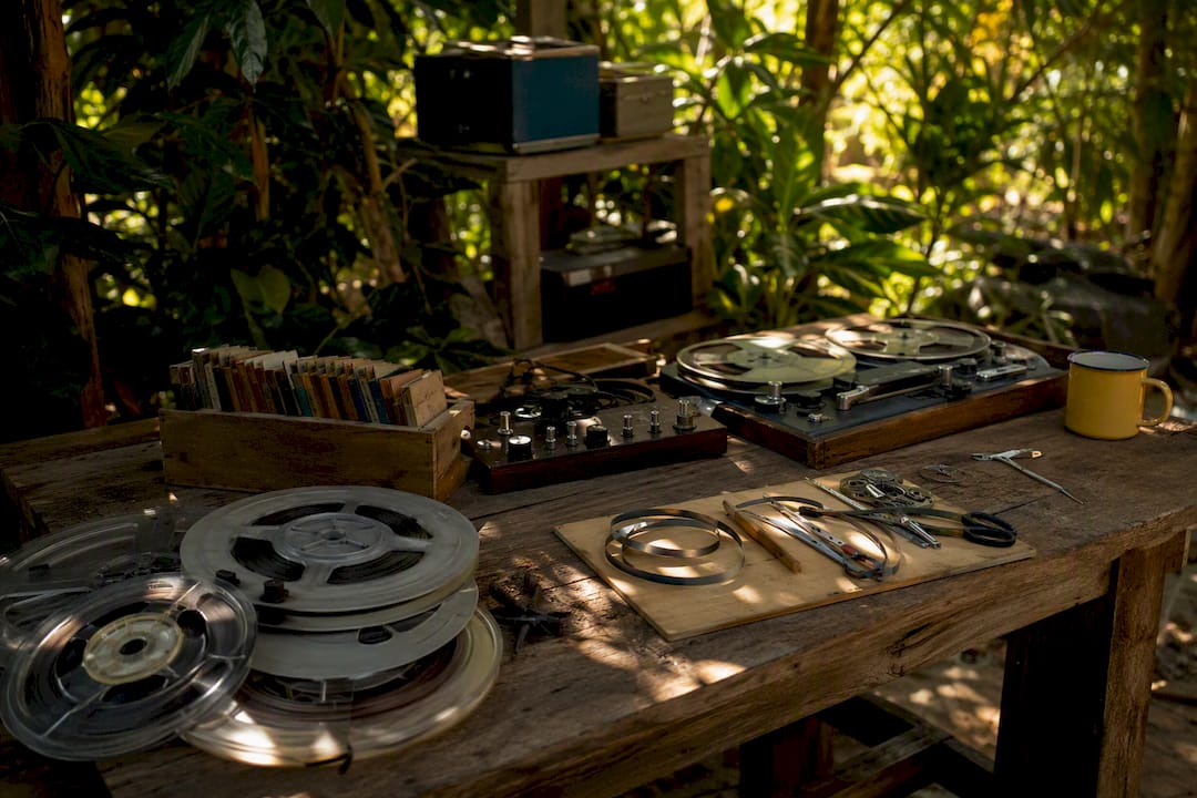 Analog audio reels and editing tools on wooden desk