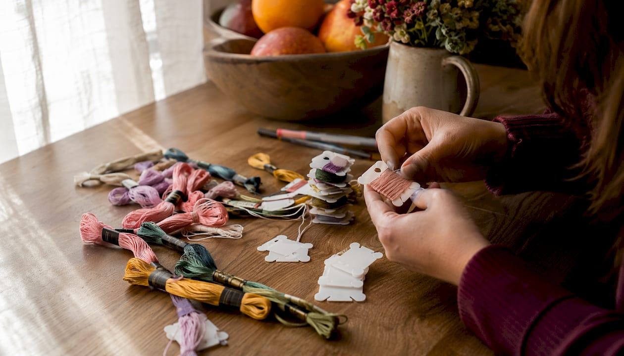 Hands winding and labeling floss bobbins
