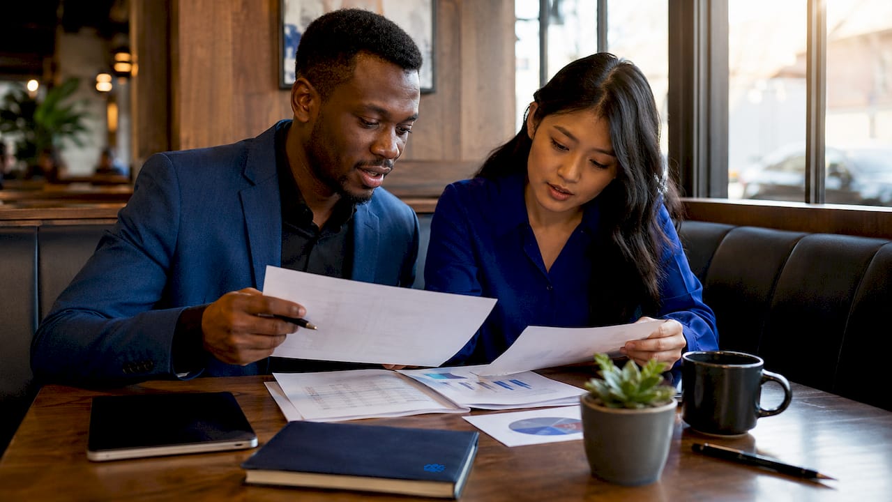 Diverse coworkers reviewing HR documents at coworking space