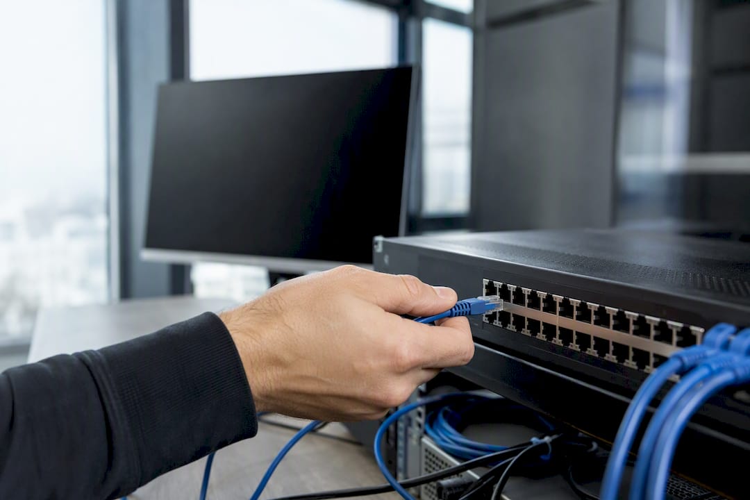 Hand plugging ethernet cable in IT room