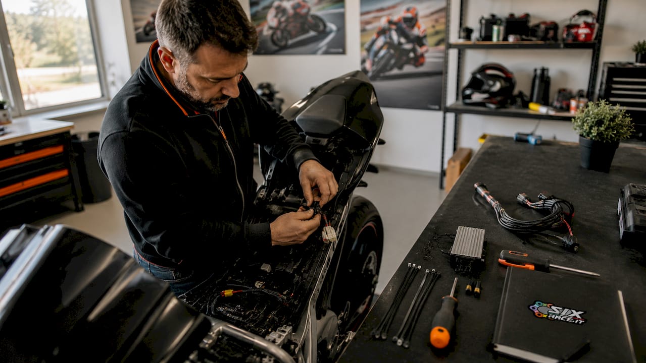 Mechaniker installiert Kraftstoffregler an der Motorradverkabelung
