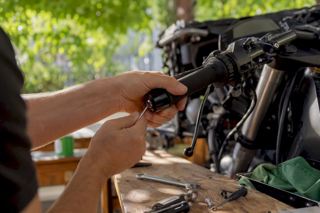 Hands installing vibration damping grips and bar end weights