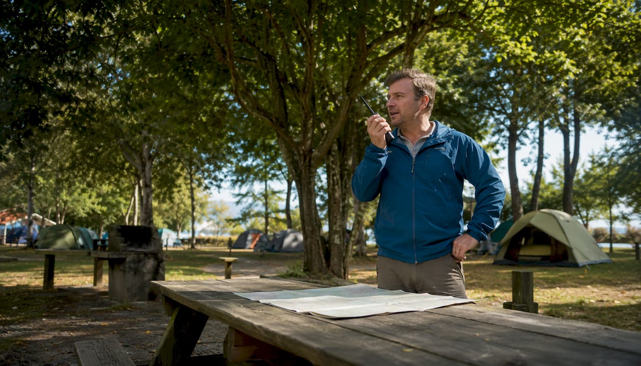 Campsite warden using walkie-talkie outdoors
