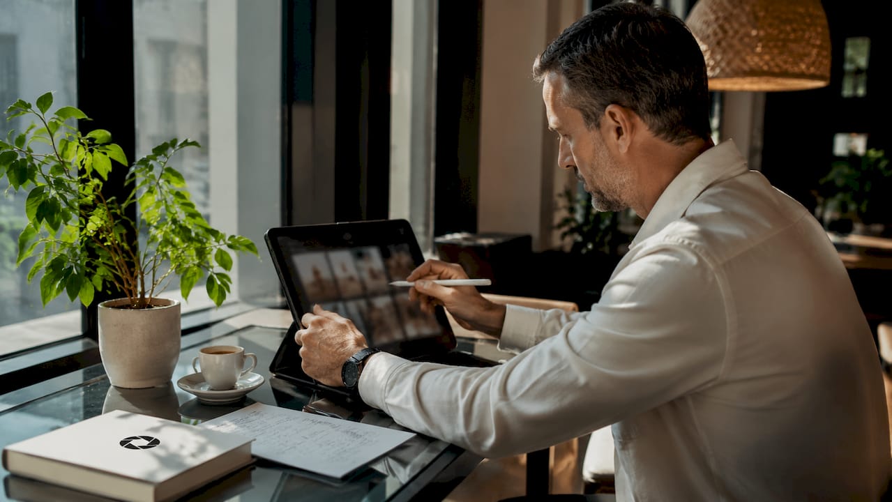 Man editing hotel images at home desk workspace