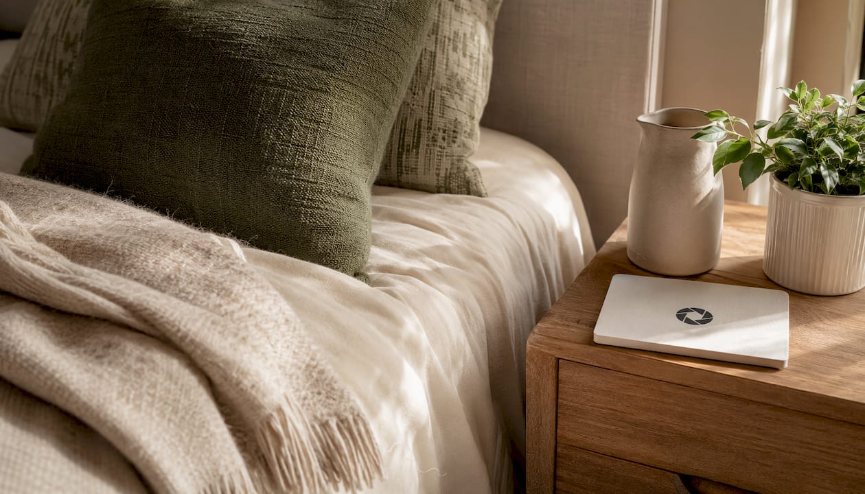 Close-up of bed corner with linens and accessories