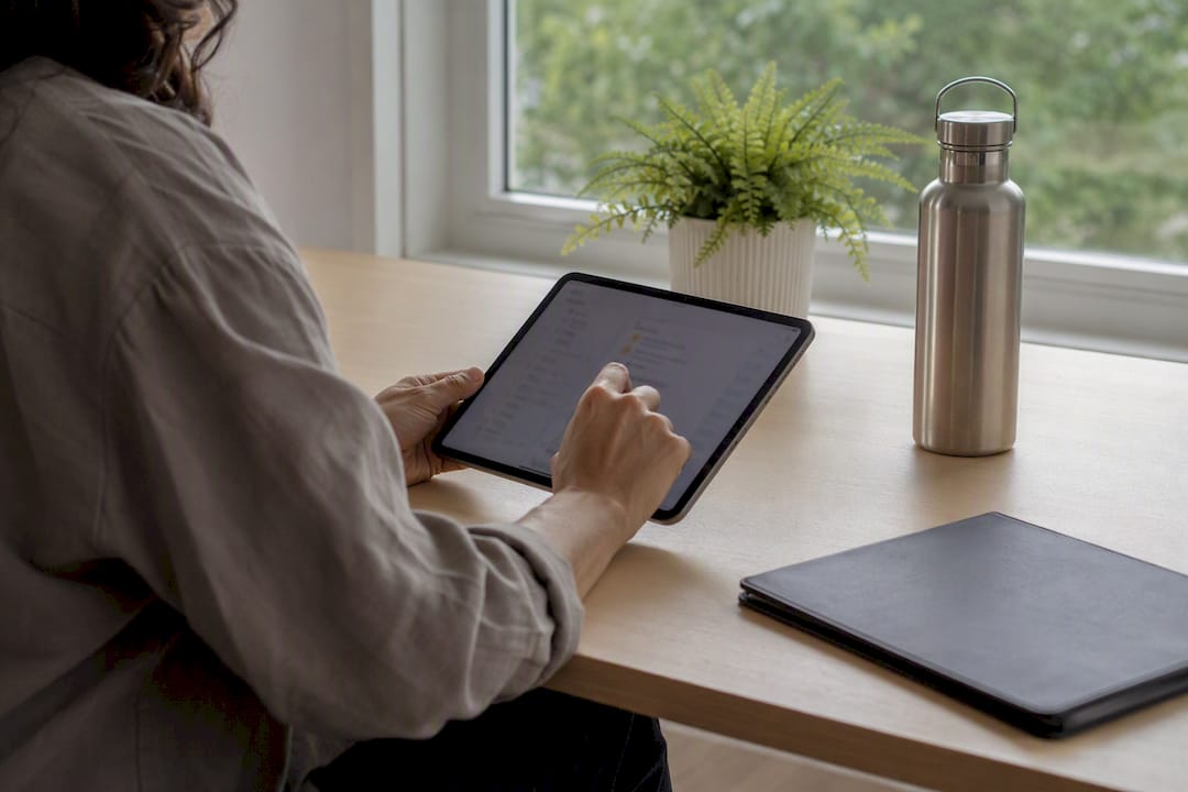 Hands organizing rental photo files on tablet