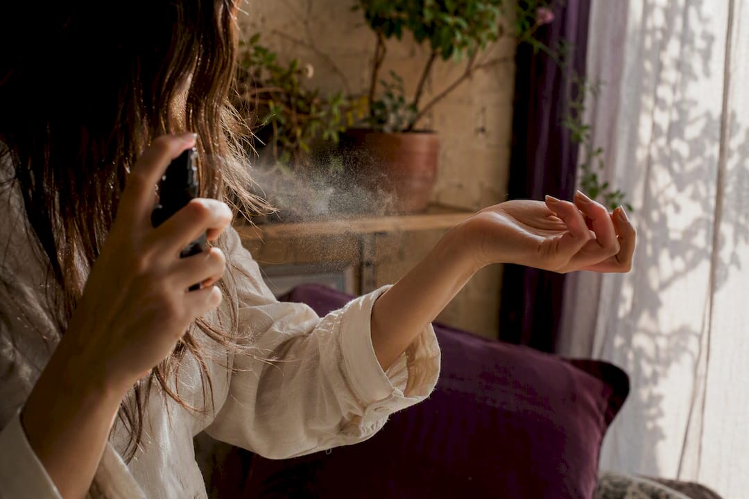 Applying aromatherapy mist on hair and wrist