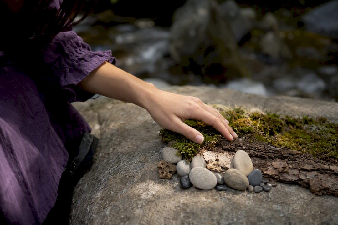 Hand touching natural tactile elements outdoors