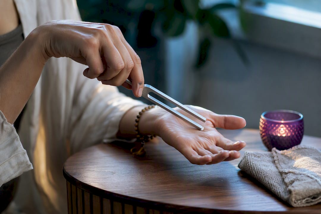 Hand using a tuning fork gently