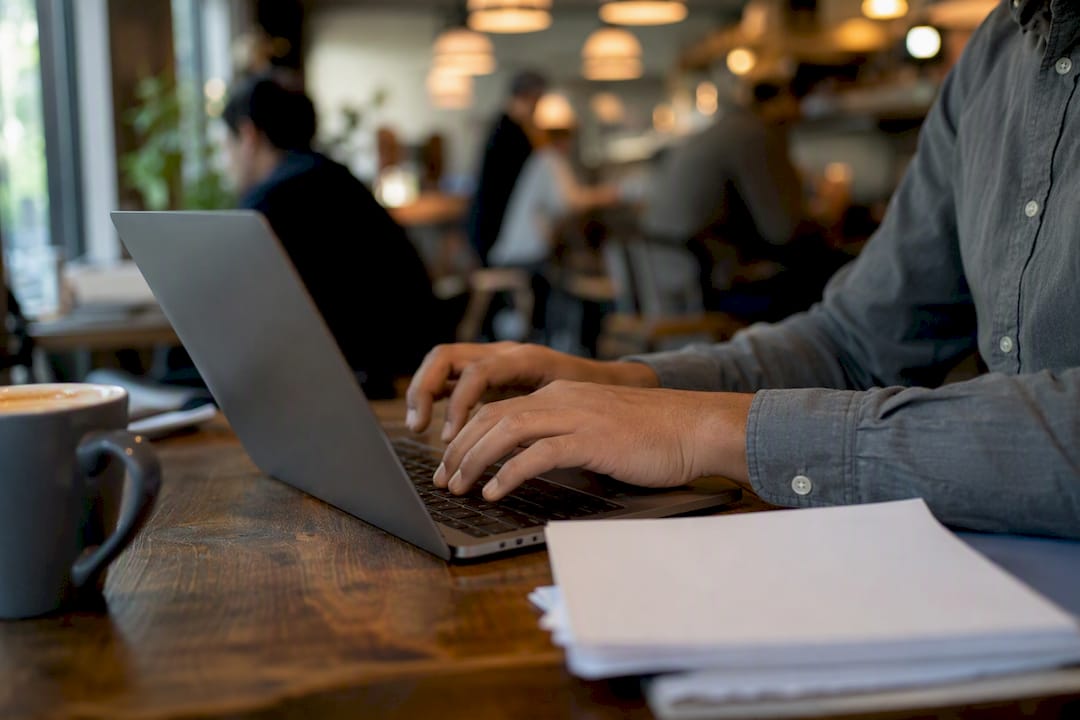 Hands typing on laptop drafting policy