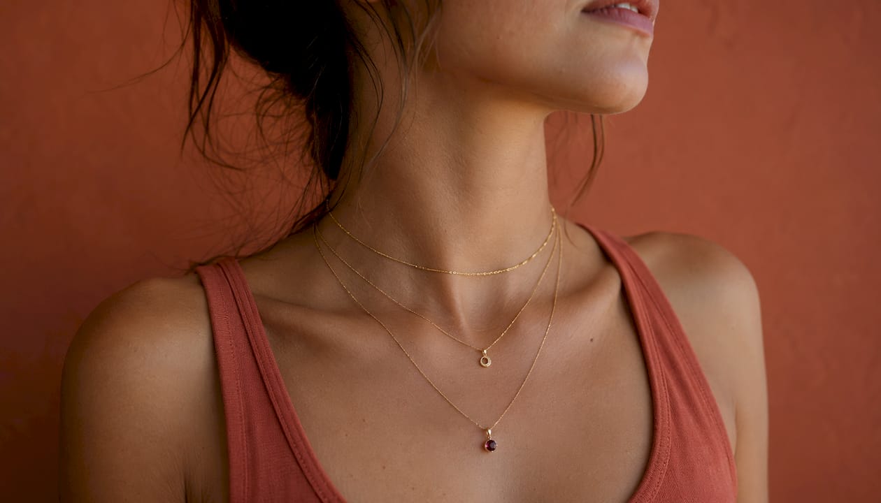Side profile neck with layered dainty gold necklaces