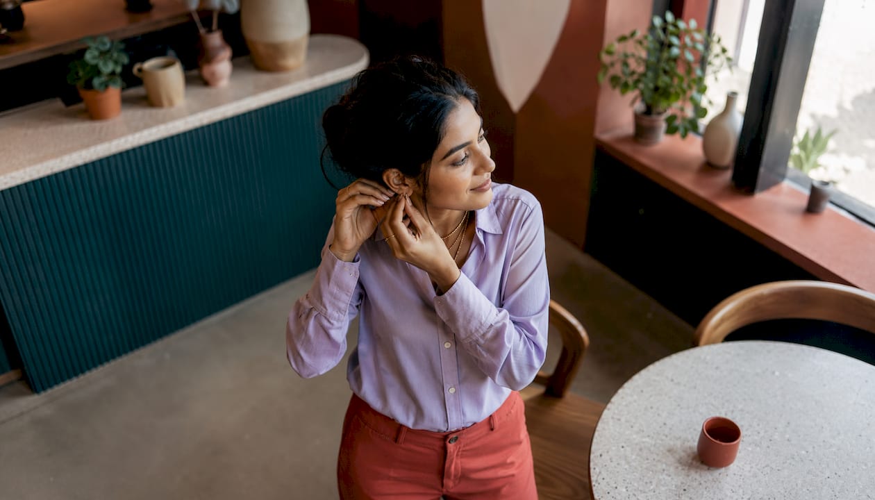 Young woman styled with gold plated jewelry indoors