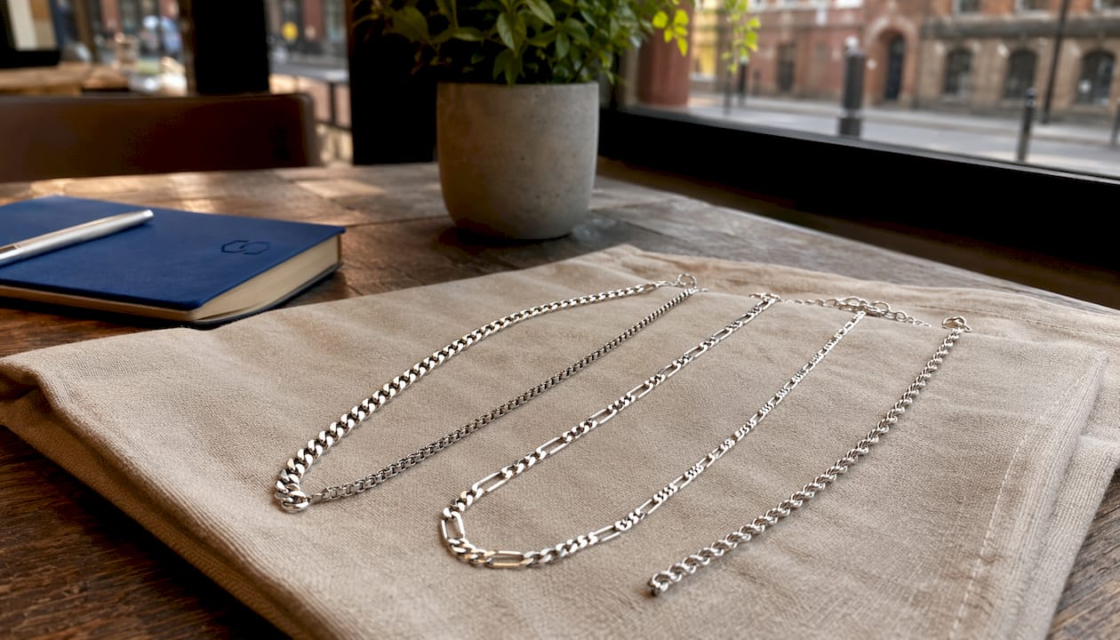 Flat lay of four silver chain styles and tools