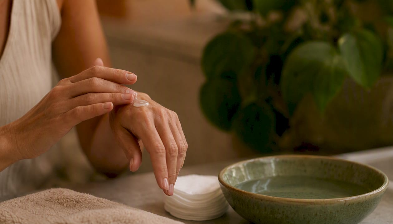 Hands applying cream during skincare routine