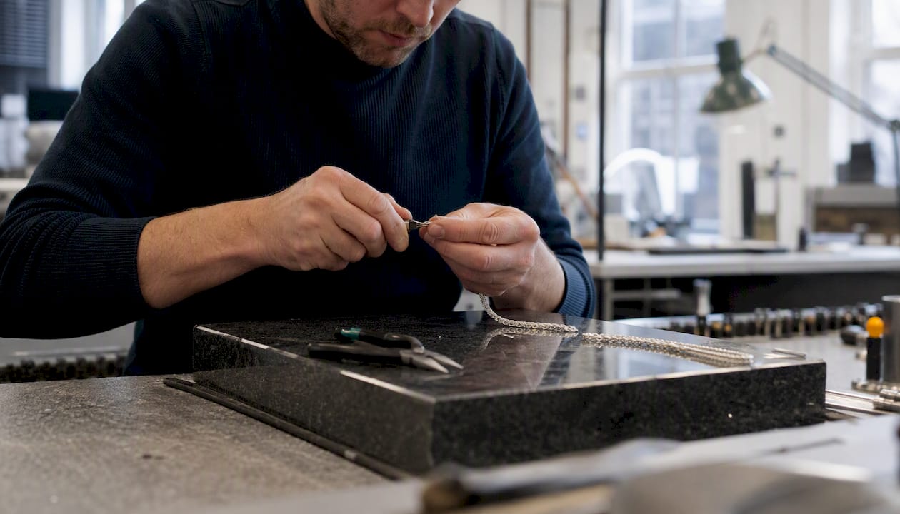 Jeweler crafting silver chain link by hand