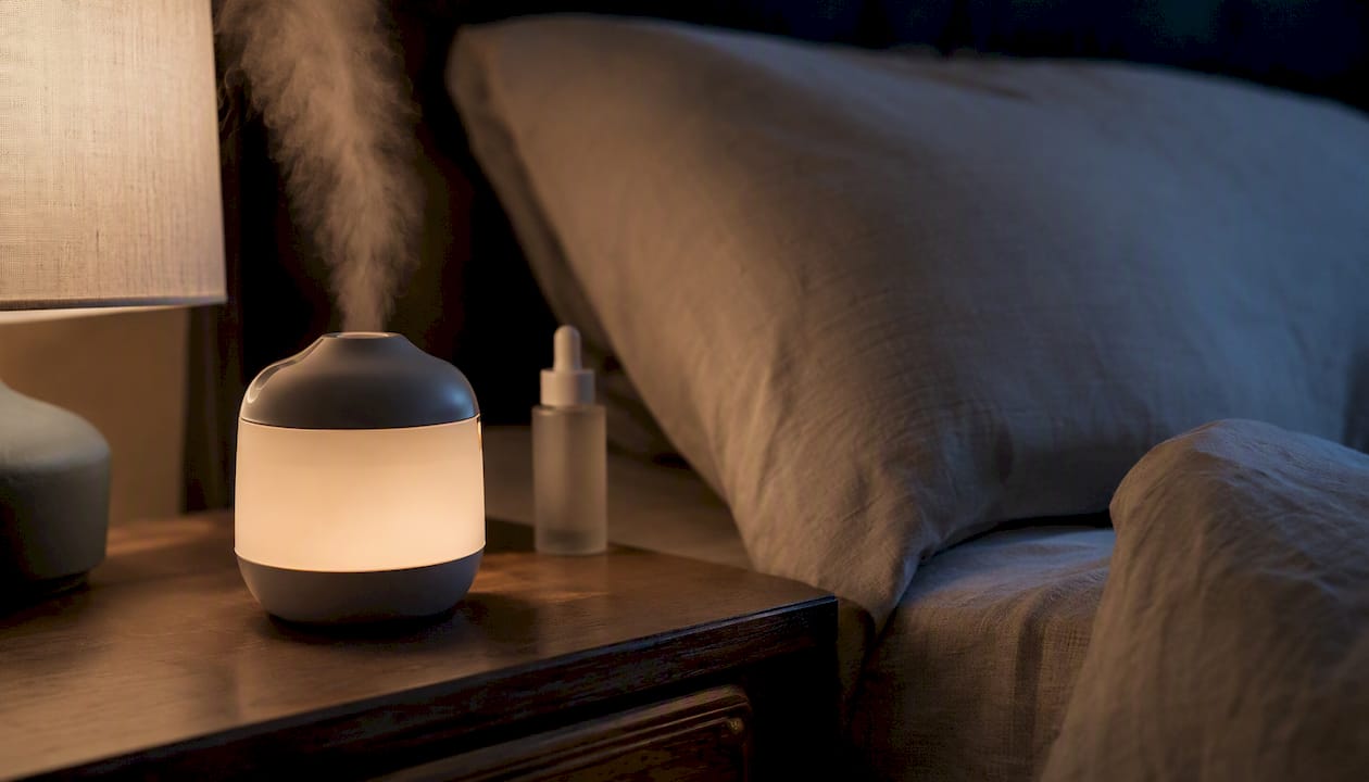 Humidifier with skincare bottle on bedside table