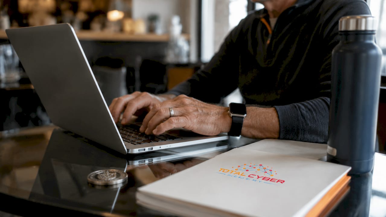 Veteran hands typing cybersecurity code at table