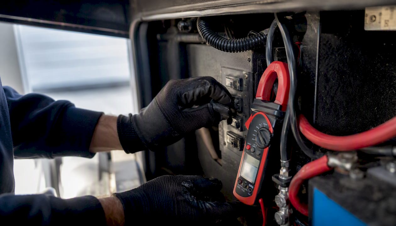 Hands testing RV 12V appliance current draw