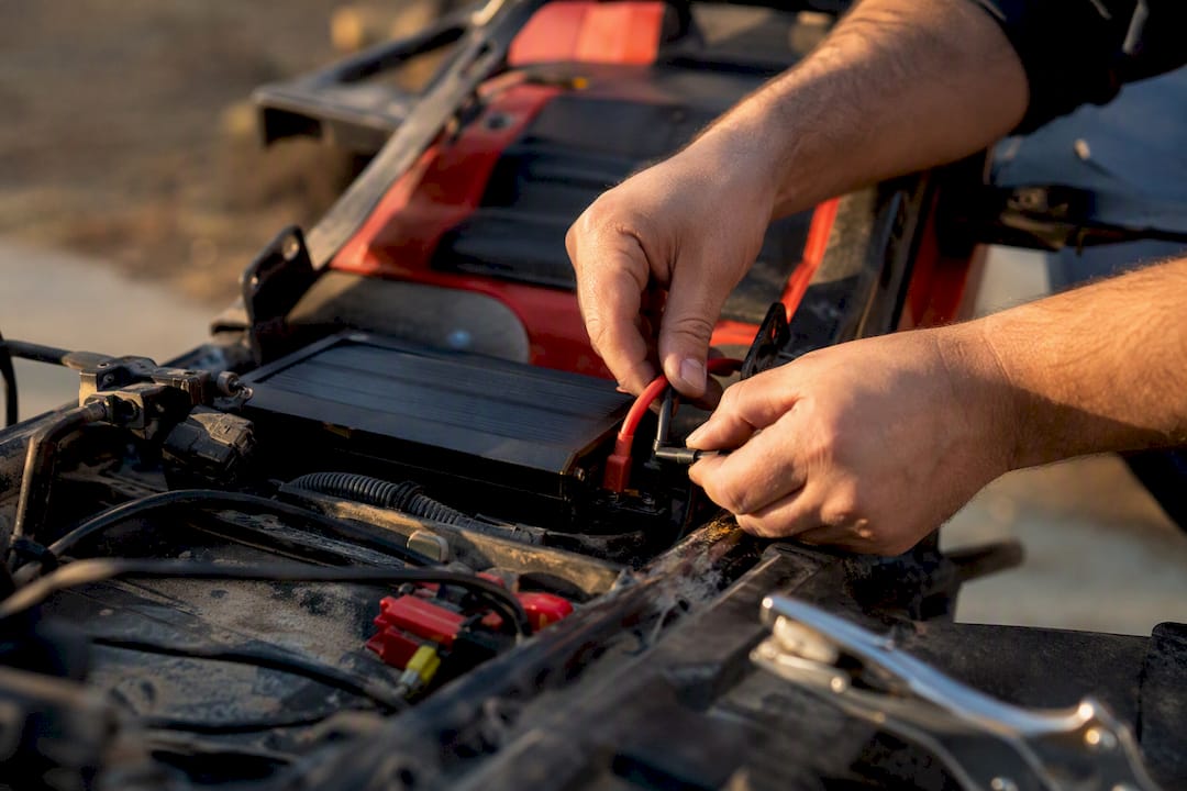 Hands wiring solar panel to battery charger