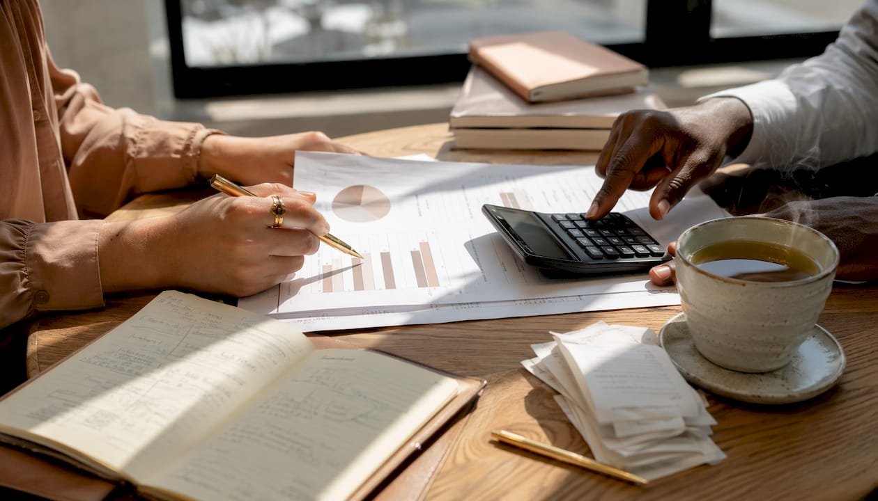 Hands comparing depreciation methods at desk