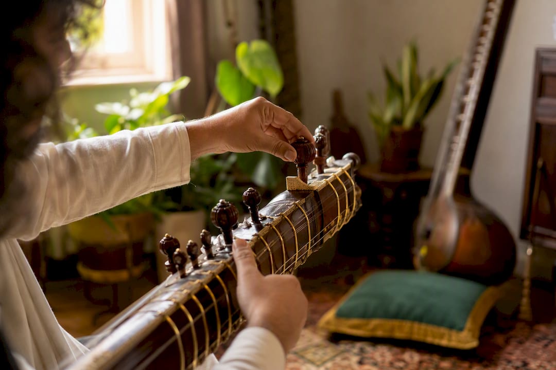 Rajib Karmakar sitarrajib Spotting Session Music: A Runbook for Composers and Editors 2 Hands tuning sitar strings in warm light