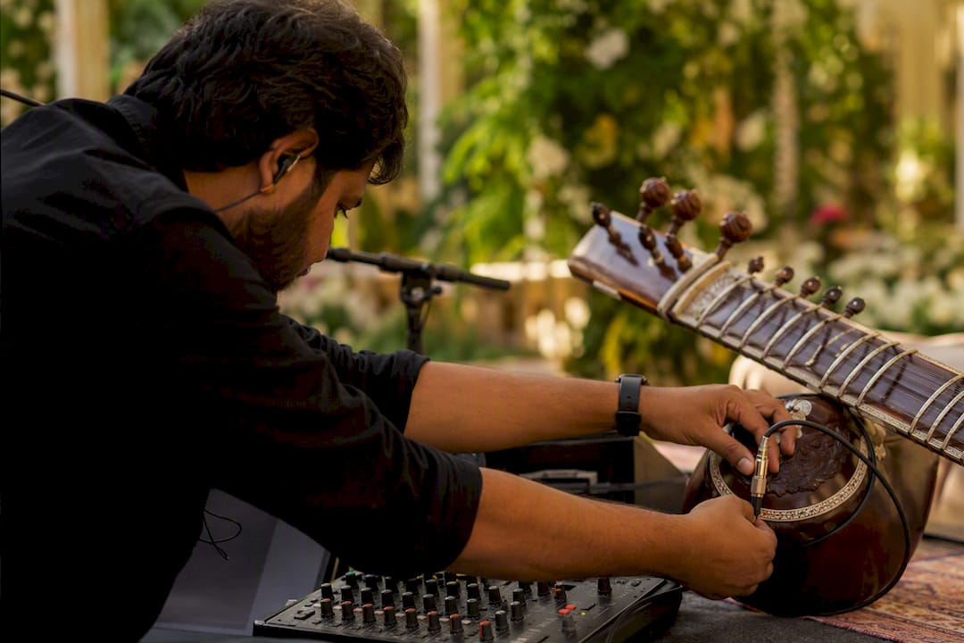 Sound technician connecting sitar mic cables