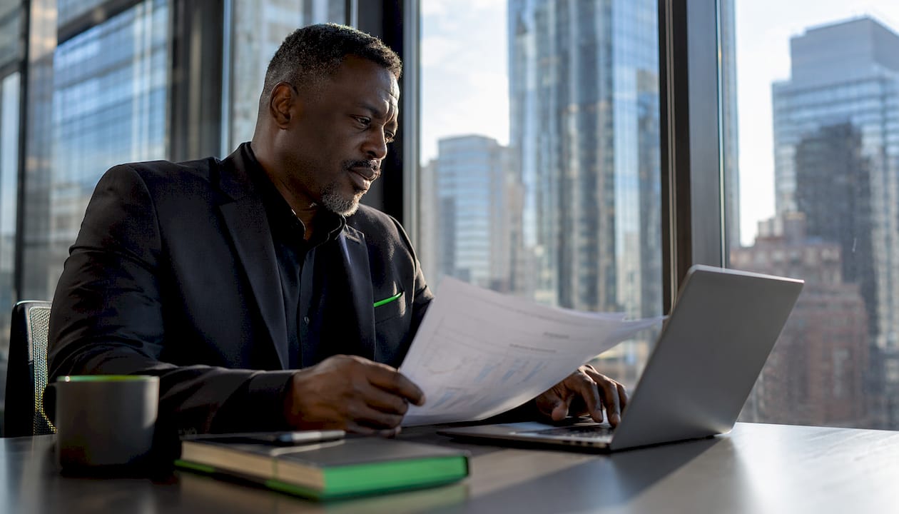 Trader reviewing earnings reports at options desk