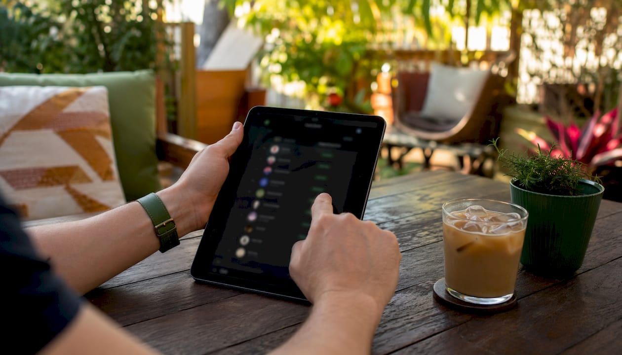Hands scrolling trader leaderboard on tablet