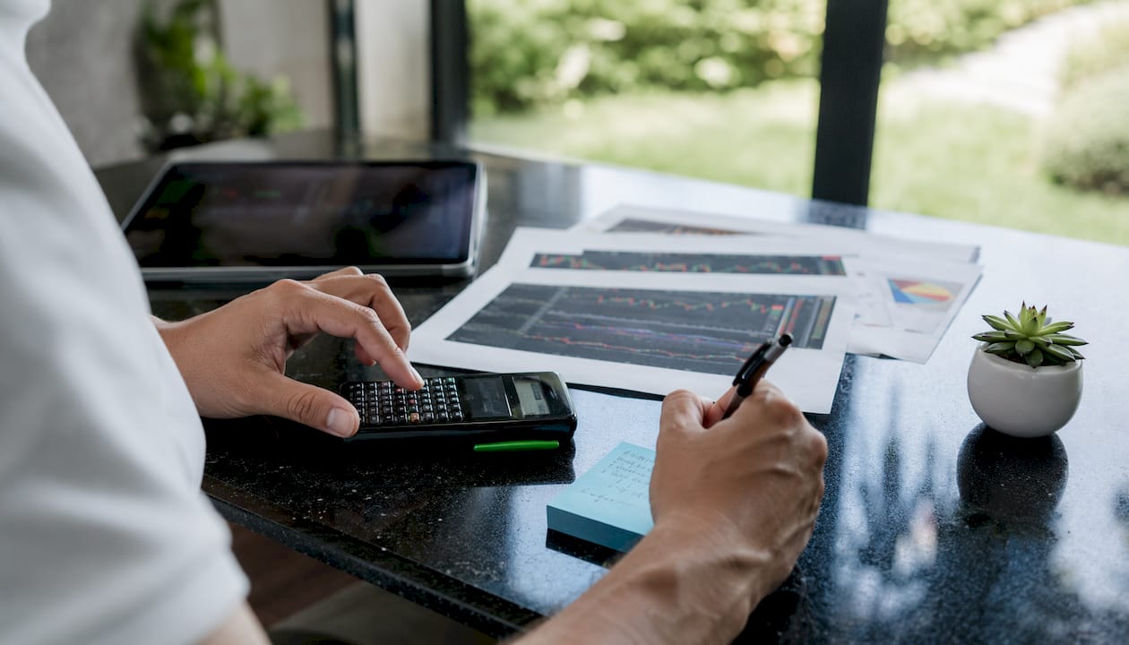 Hands calculating risk score to dollar exposure