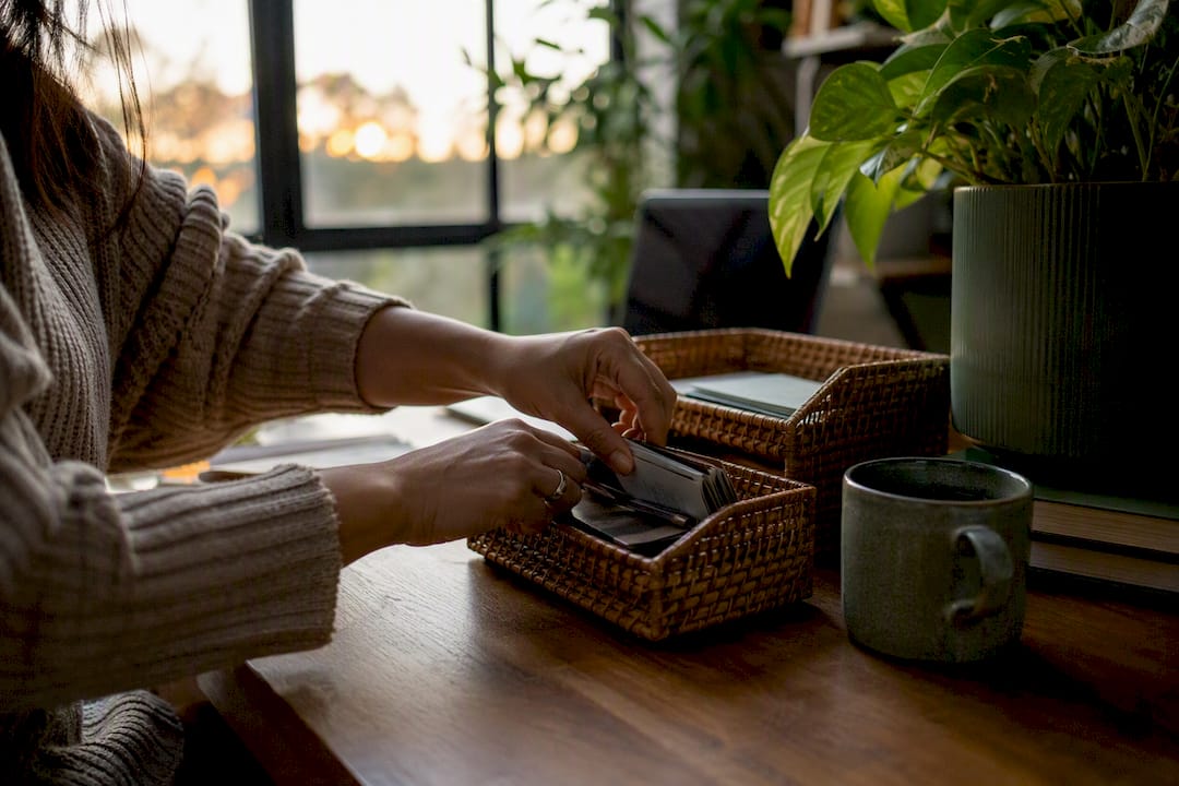 Hands sorting desk items during decluttering