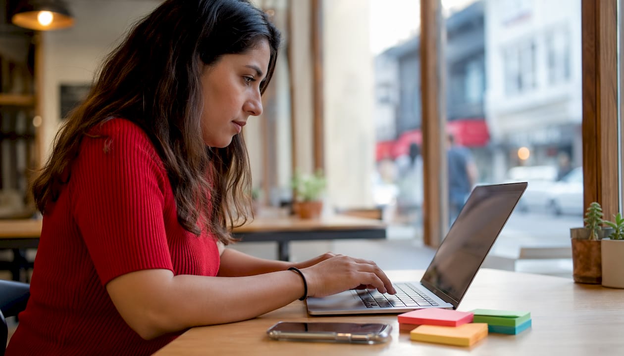 Hands typing on laptop managing rota software