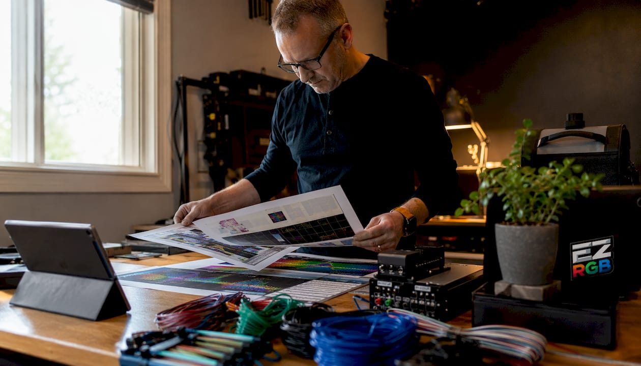 Person planning holiday light show setup at kitchen table