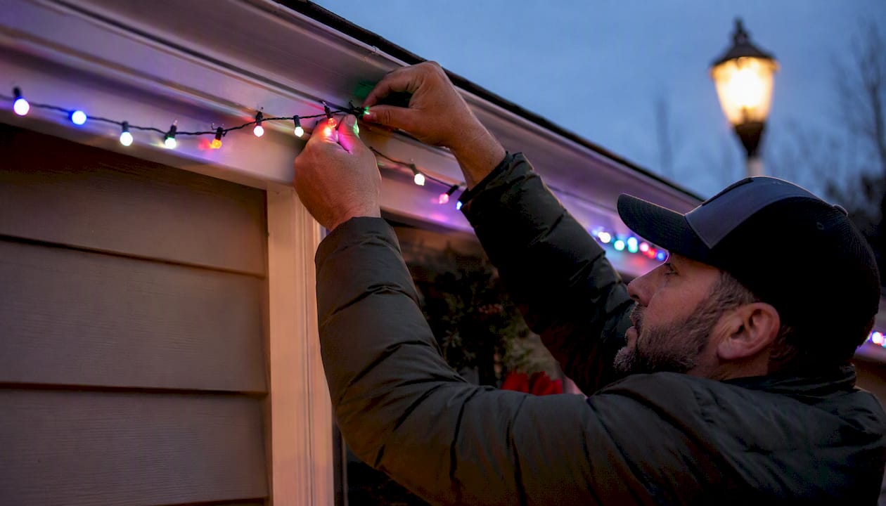 Homeowner installing RGB pixel light strand outdoors