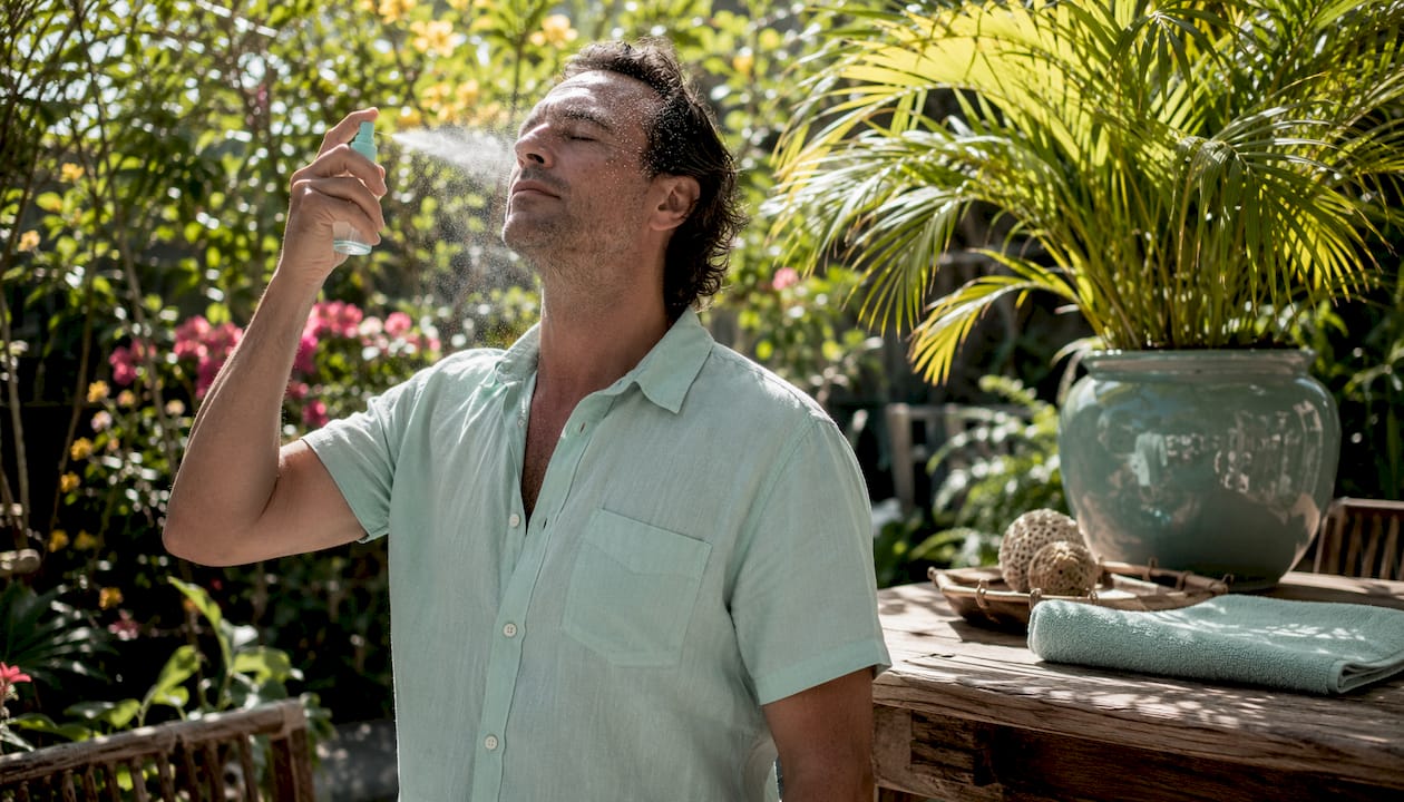 Man using SPF facial mist at home
