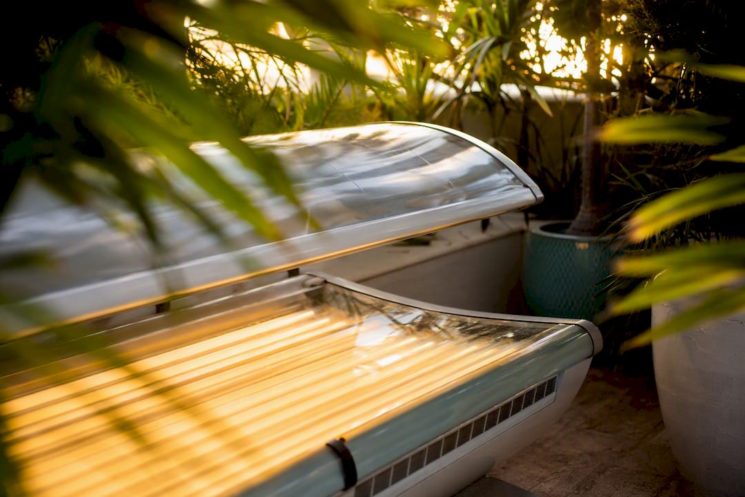 UV tanning bed bulbs glowing inside a salon room