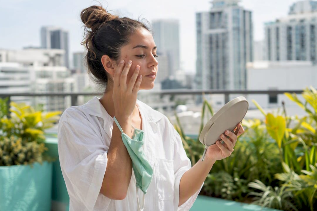 Woman touching face on sunny city street