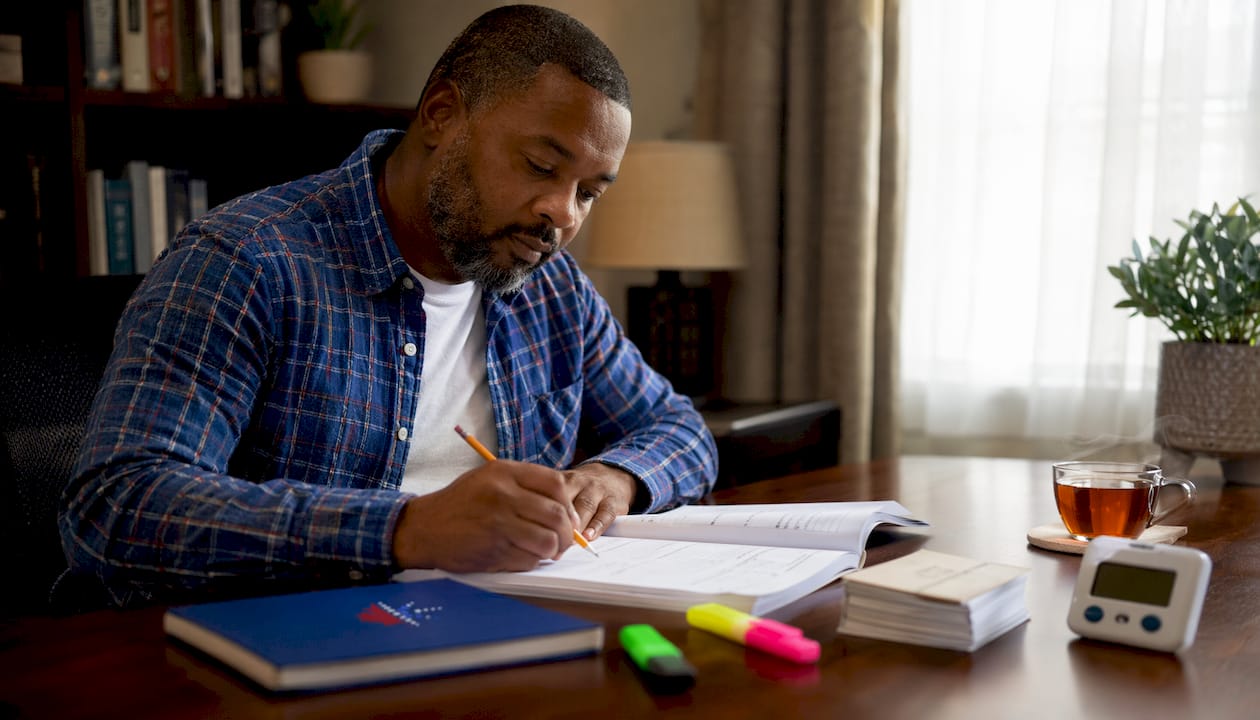 Man taking English proficiency assessment at library table
