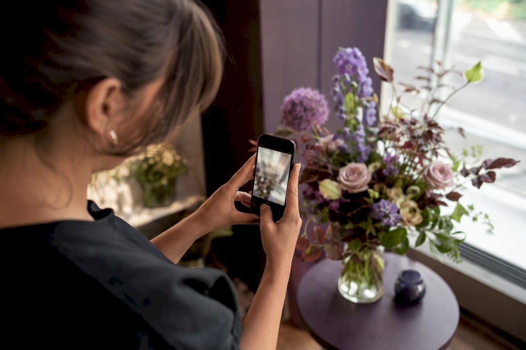 Florist photographing bouquet for delivery confirmation
